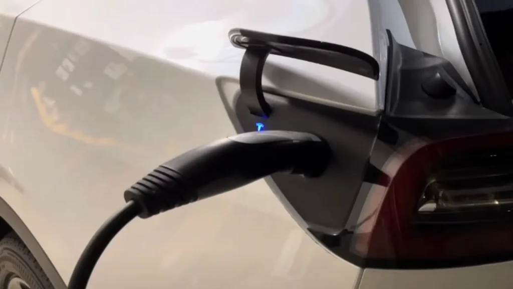 A close up image showing the Lectron Level 1 Tesla charger plugged into a Tesla charging inlet