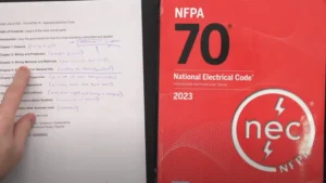 James pointing at Chapter 3: Wiring Methods and Materials in the National Electrical Code (NEC) book