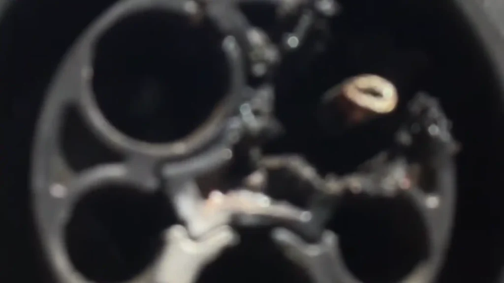 Close-up of a melted SAE J1772 EV charging plug with severe heat damage, blackened plastic, and burned charging pins caused by overheating and poor electrical contact.